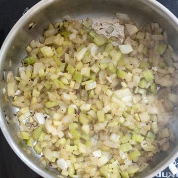 Celery and onions sauteing in pan.