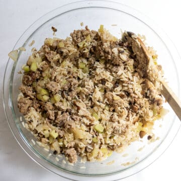 All dressing ingredients combine with parmesan in a bowl.