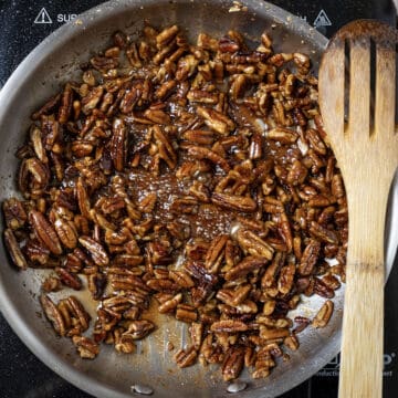 Caramelizing sugar to pecans in the pan.