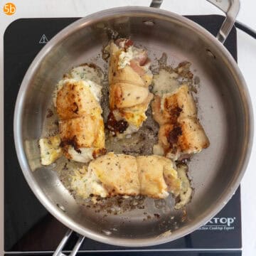 Chicken flipped and golden brown on one side while being fried.