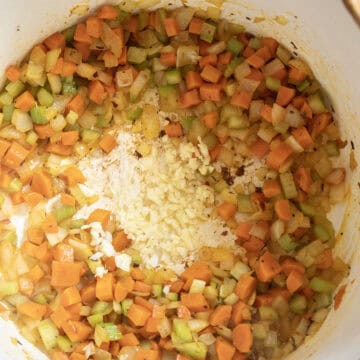 Garlic added to the pot with carrots, onion, and celery to saute.