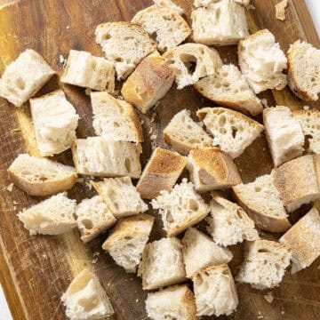 Chopped up bread on a cutting board.