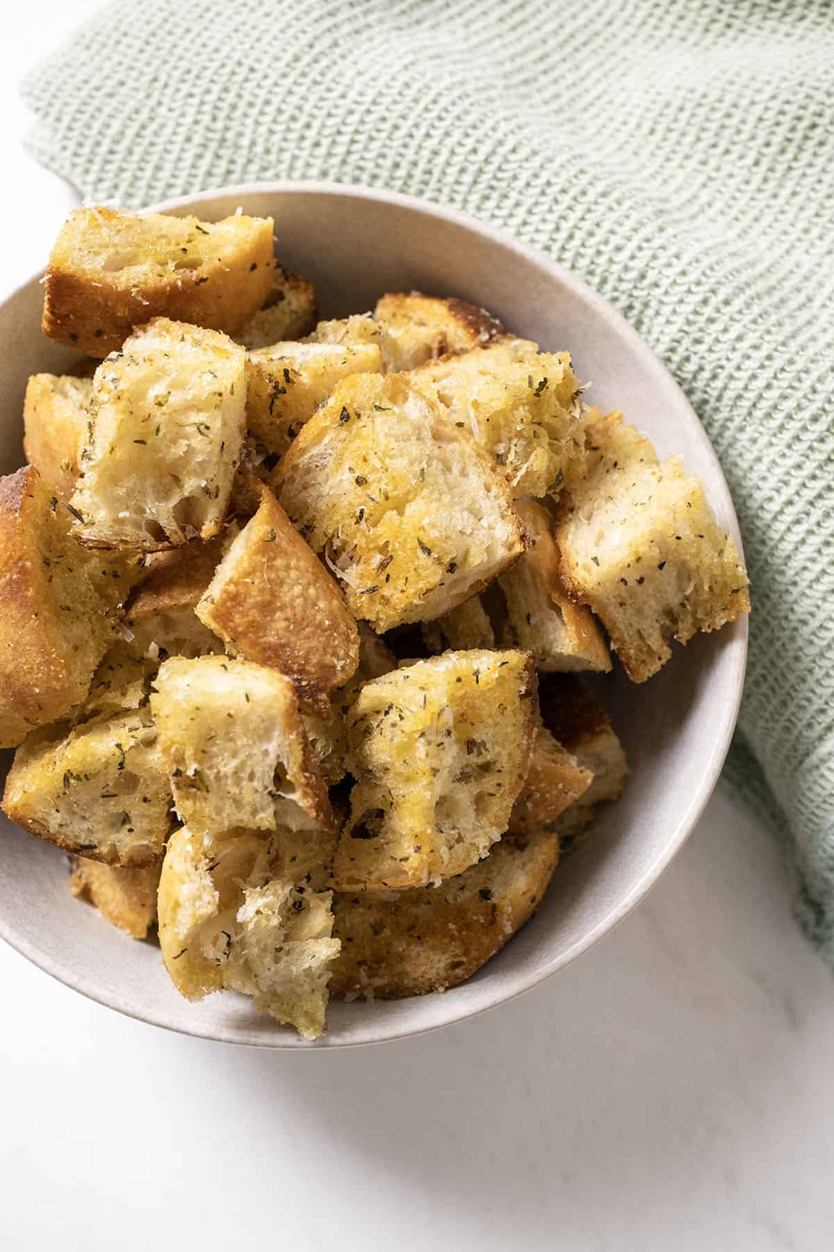 Parmesan seasoned croutons in a bowl.