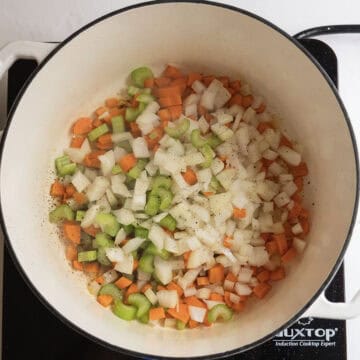 Sauteing carrots, celery and onion in the pot.