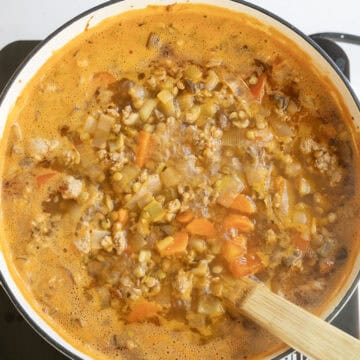 Lentil soup simmering in a pot.