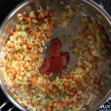 Tomato paste caramelizing in a saucepan.