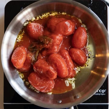 Whole plum tomatoes added to sauteed olive oil.