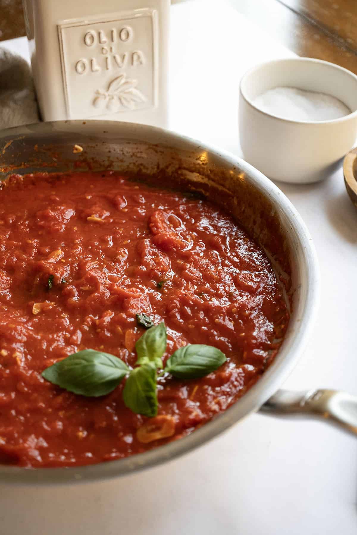 Marinara sauce in a pan garnished with basil.