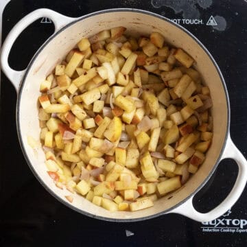 Seasoned apples in the dutch oven sauteing.