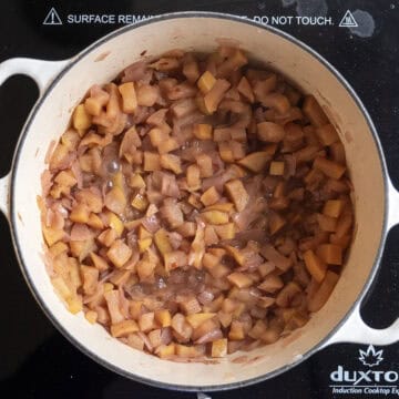Apples halfway through simmering in dutch oven softening.