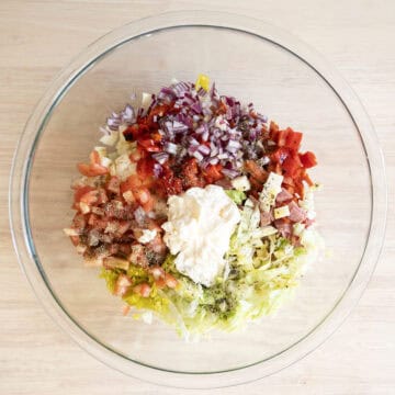 Combined ingredients with mayo, olive oil, seasoning, and vinegar.