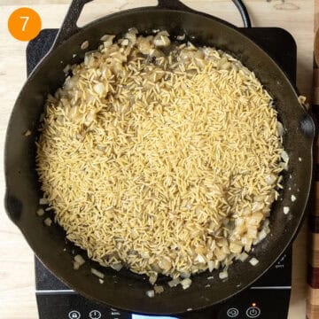 Orzo added to the pan and combined with onions and garlic.