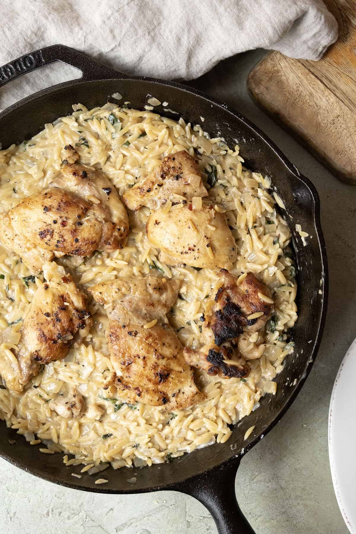 Charred chicken thighs over a bed of creamy orzo.