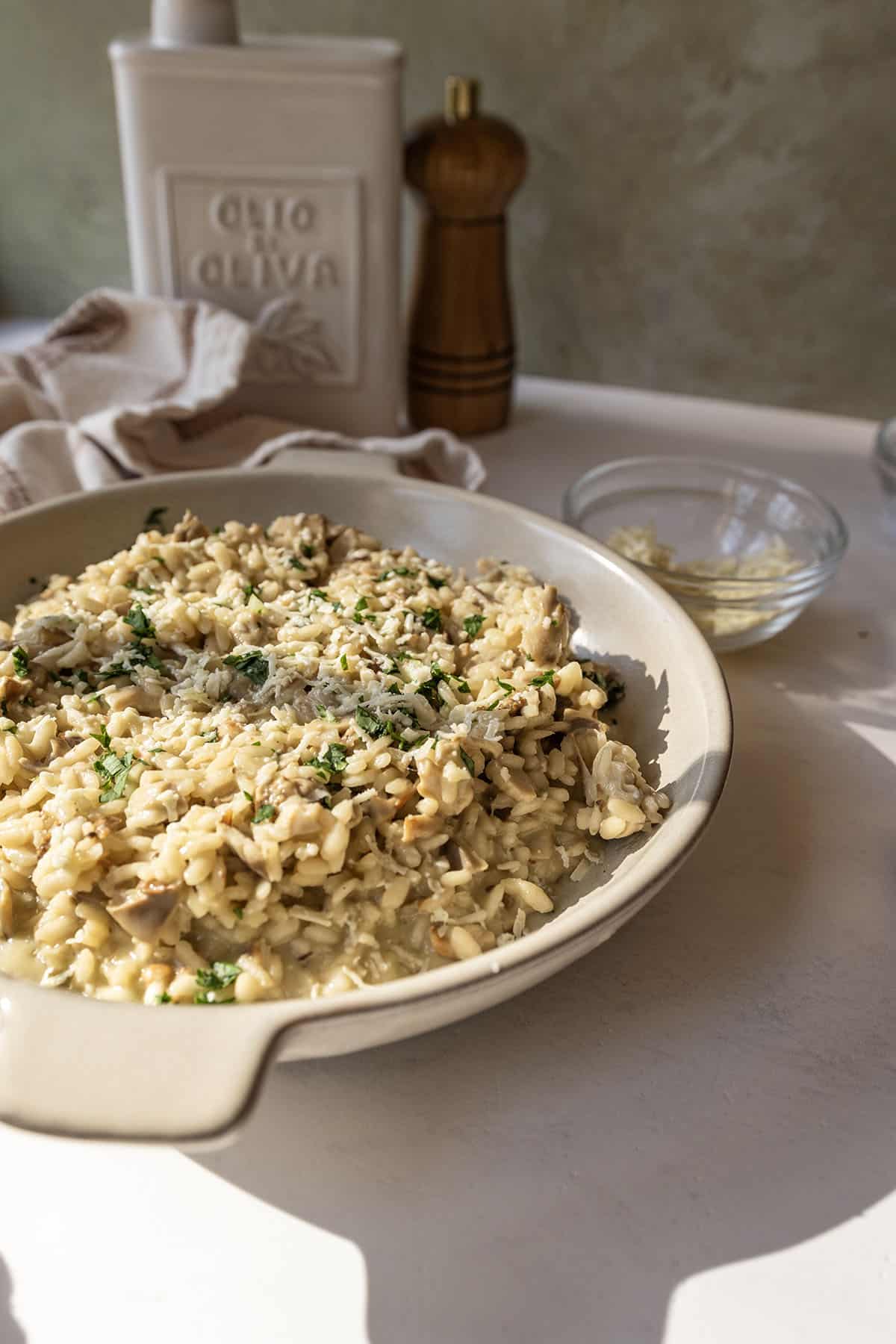 A bowl of risotto with mushrooms topped with extra gorgonzola and parsley.