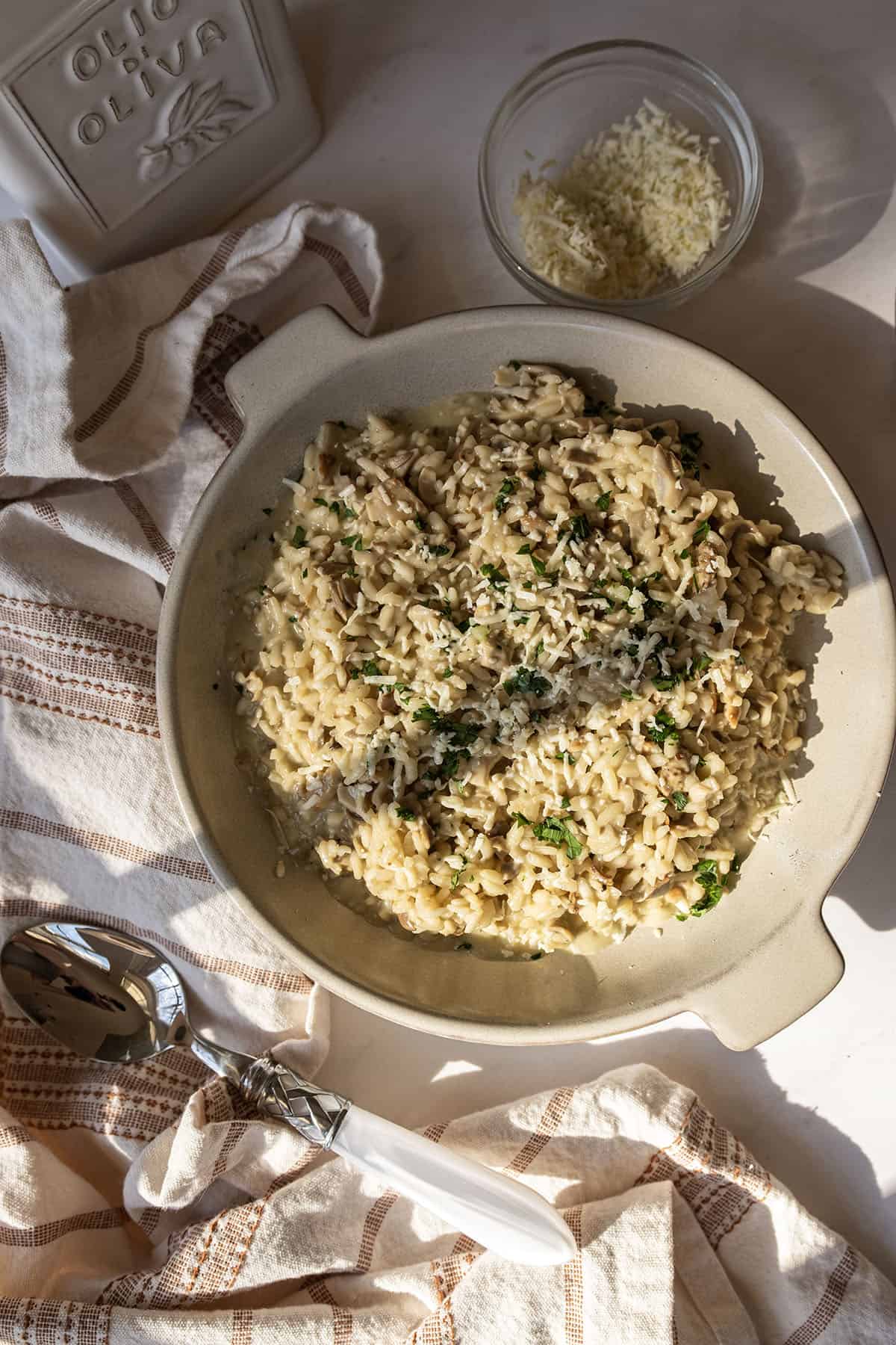 A bowl of risotto with mushrooms topped with extra gorgonzola and parsley.