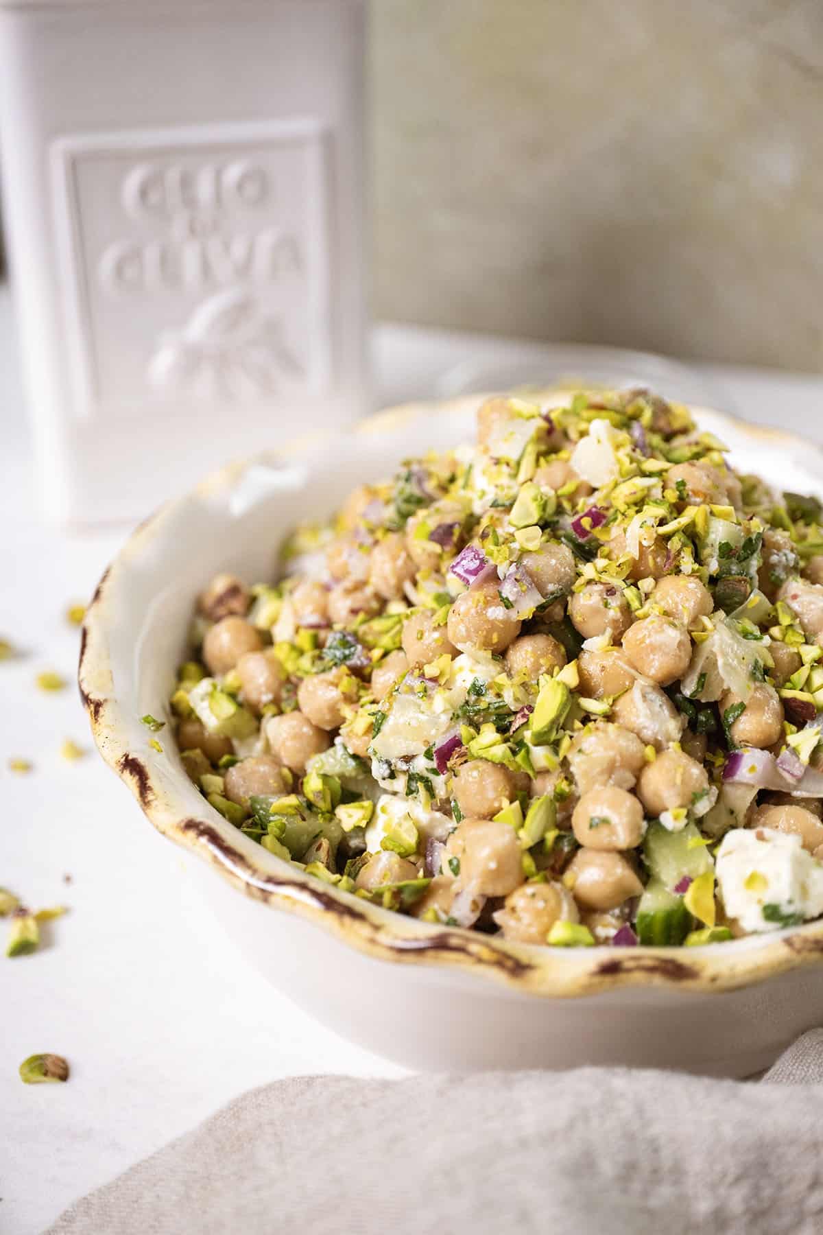 Chickpea and feta salad in a bowl topped with pistachios