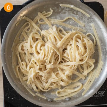 Finished creamy fettucine alfredo in a pan.