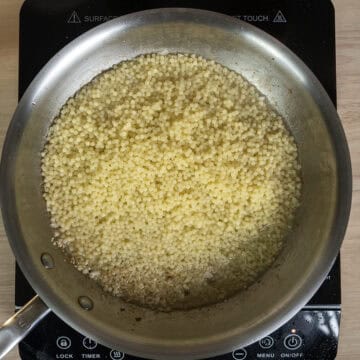 Pastina and pasta water added to the pan with garlic.