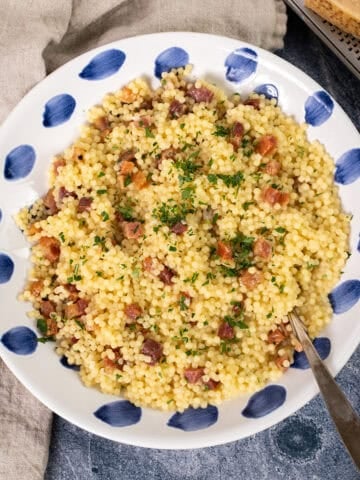 Pastina with pancetta and parsley in a bowl.