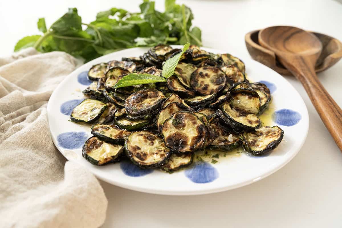 Zucchini alla scapece on a plate topped with mint.