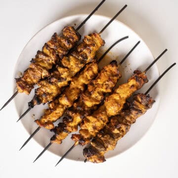 Bang Bang Chicken skewers on a plate.