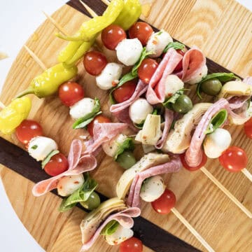 Vegetables, cheese, and salami on a skewer.