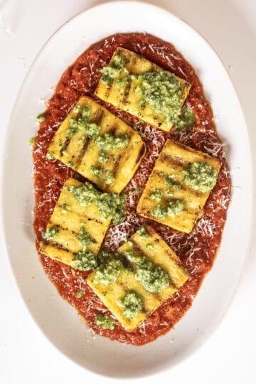 Plate of marinara with polenta and pesto.