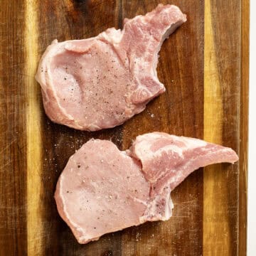 Bone in pork chops seasoned with salt and pepper.