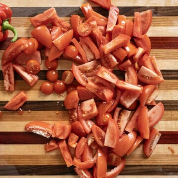 Chopped assorted tomatoes on a cutting board.
