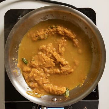 Pasta water added to pumpkin puree in the pan.