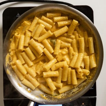 Tossing pasta in the creamy pumpkin sauce.