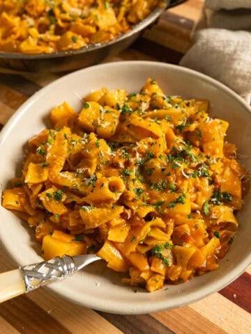 Pasta and Potatoes on a plate topped with parsley and parmesan.