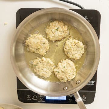Frying cauliflower cakes in olive oil.