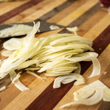 Shaved fennel on a cutting board.