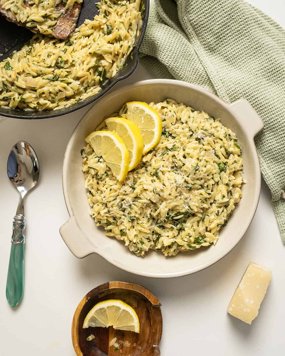 Lemon spinach orzo in a bowl topped with lemon garnish.