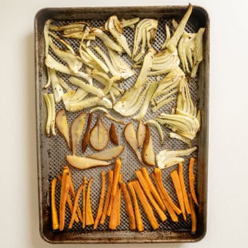 Roasted fennel, carrots, and pears on a baking pan.
