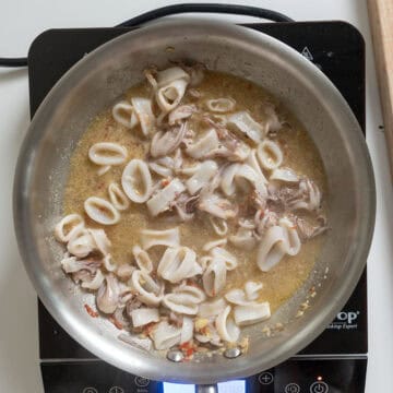 Simmering calamari with garlic, chiles, and anchovies in white wine.