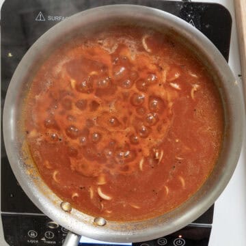 Simmering calamari with garlic, chiles, and anchovies with passata.
