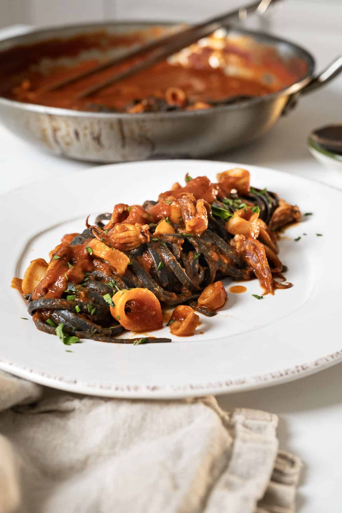 Squid ink pasta with calamari on a plate.