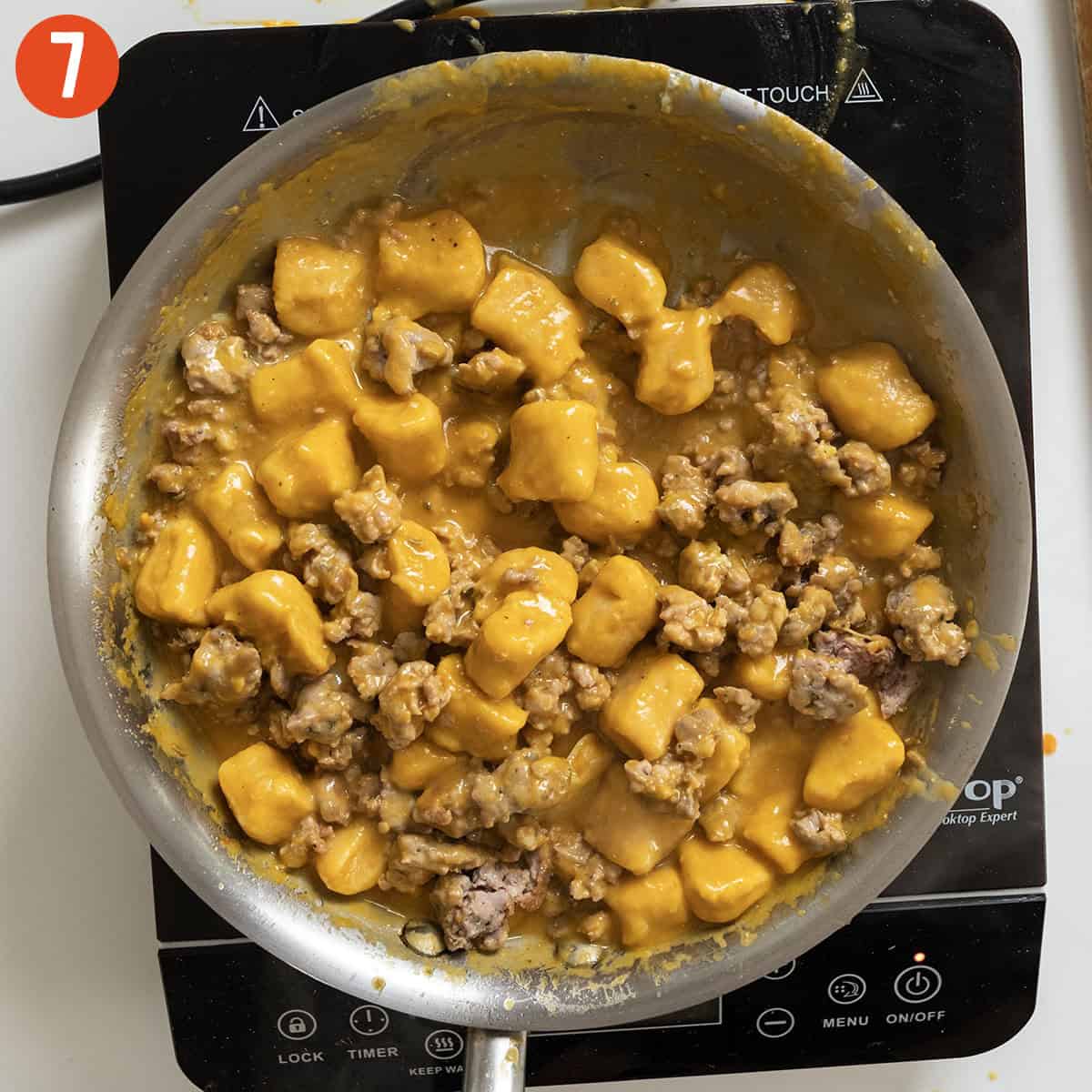 Sausage added to pumpkin sauce with gnocchi.