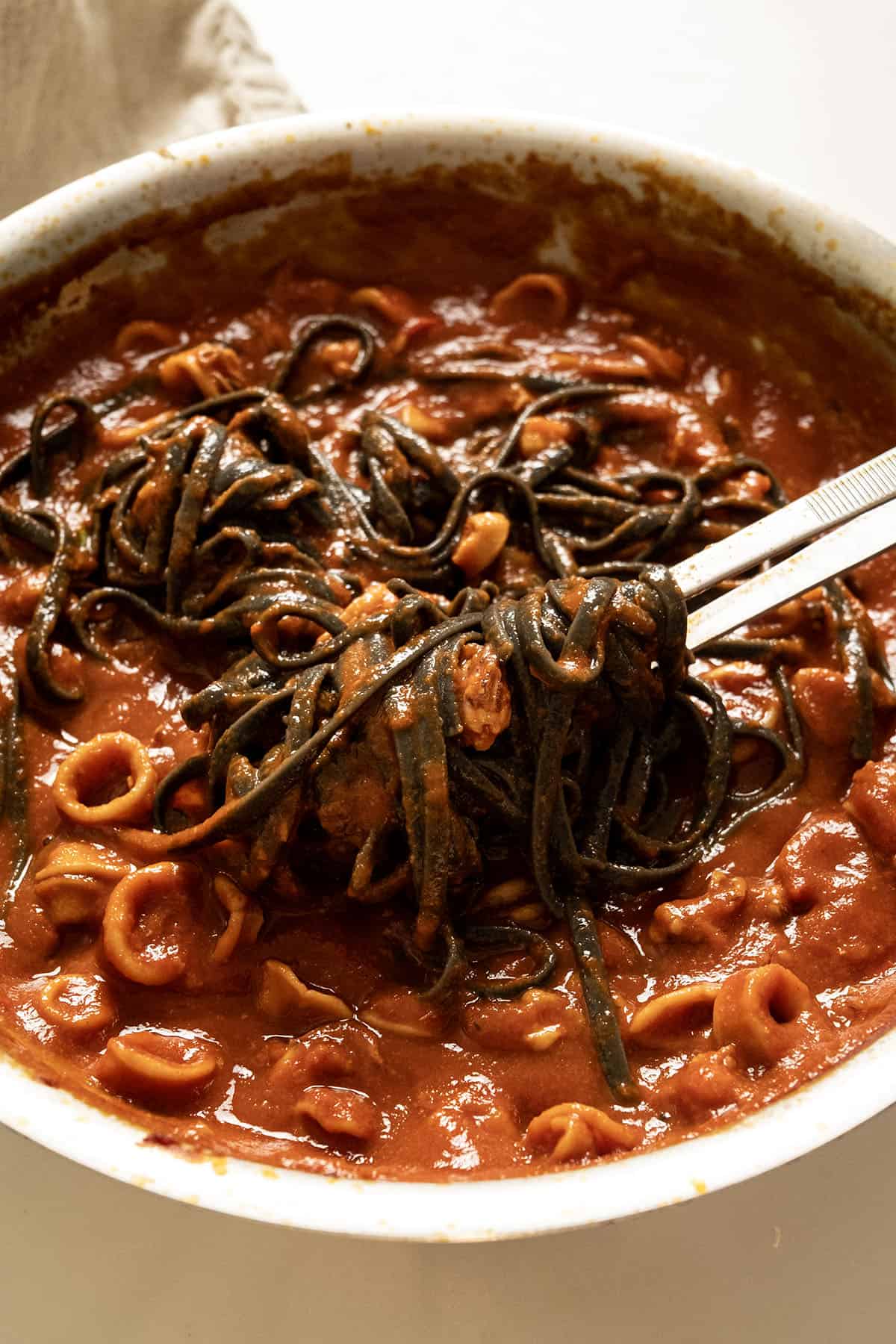 Squid ink pasta with calamari in the pan.