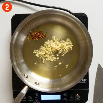 Sauteing garlic and crushed red peppers in oil.