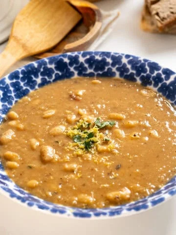 Fennel and white bean soup in a bowl topped with parsley and lemon zest.