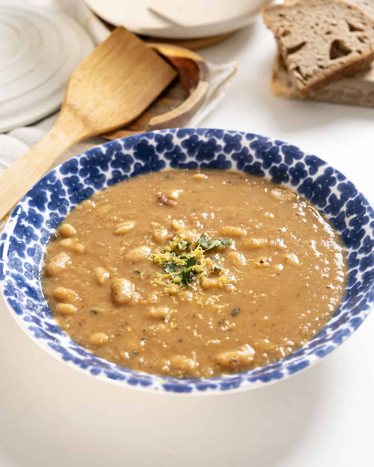 Fennel and white bean soup in a bowl topped with parsley and lemon zest.