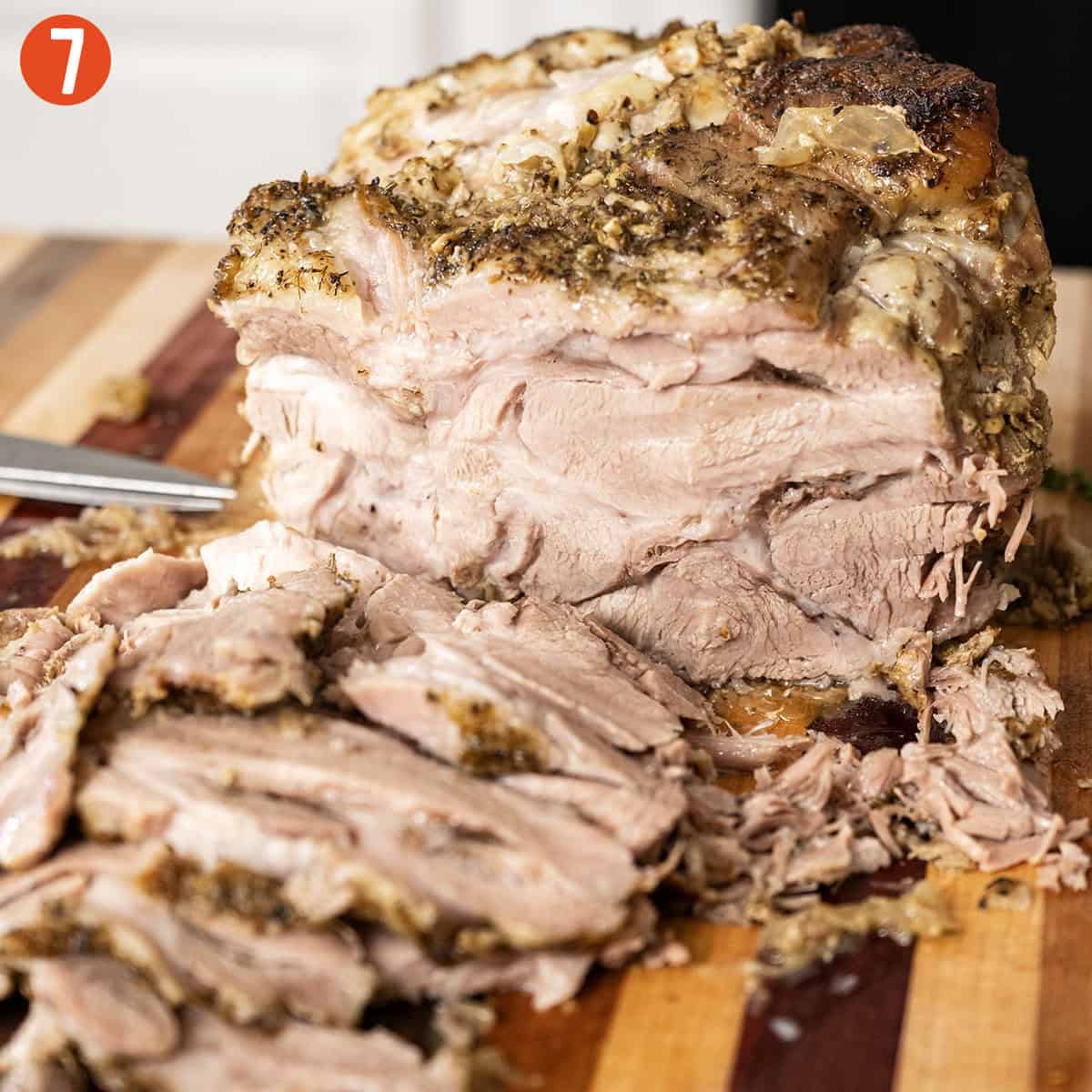 Sliced pork shoulder on a cutting board.