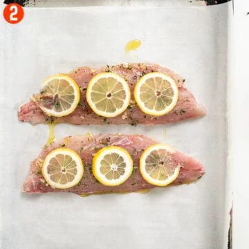 Red snapper placed on a baking tray with parchment paper.