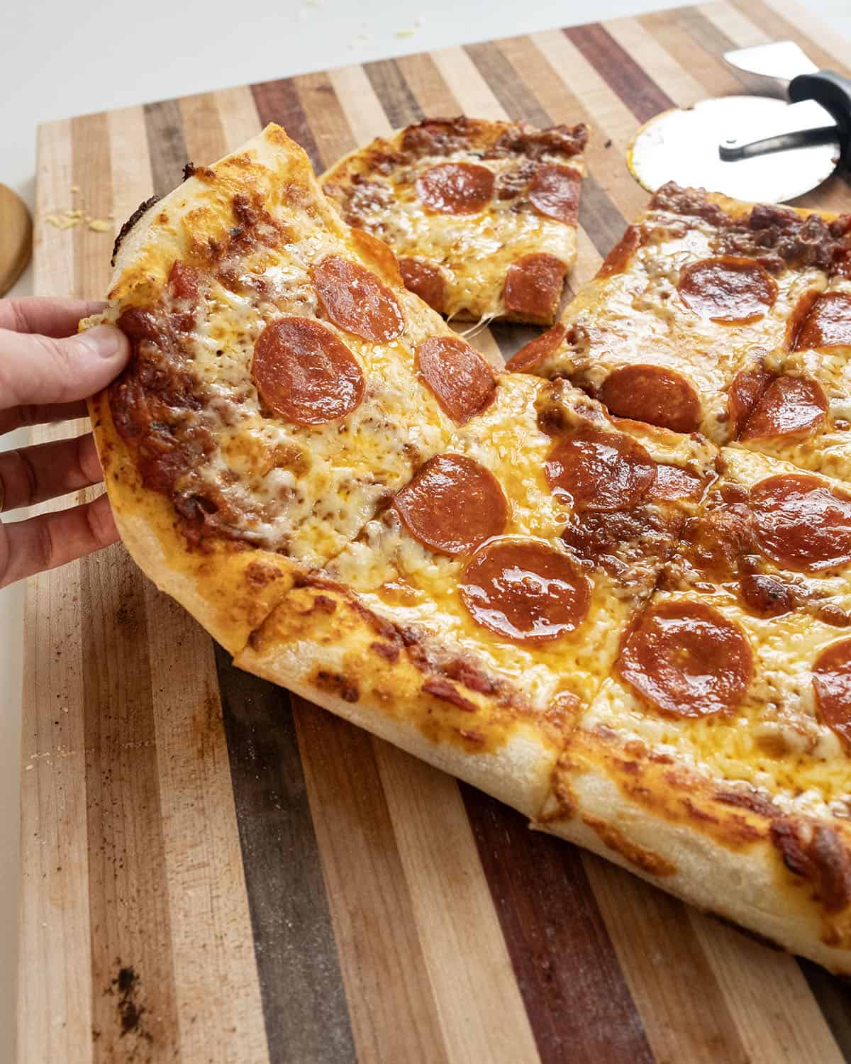 NY Style Pizza with pepperoni, cut on a cutting board.