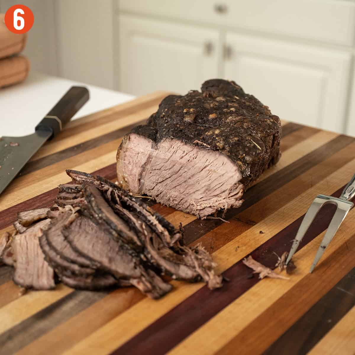 Slicing roast beef on a cutting board.
