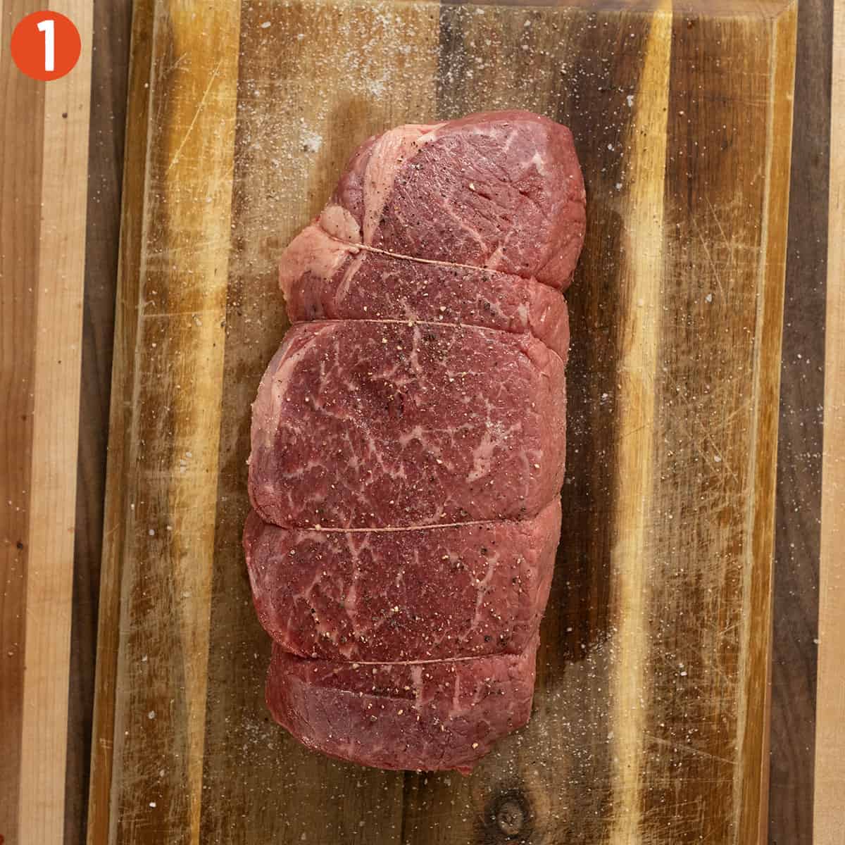 Seasoning roast beef with salt.