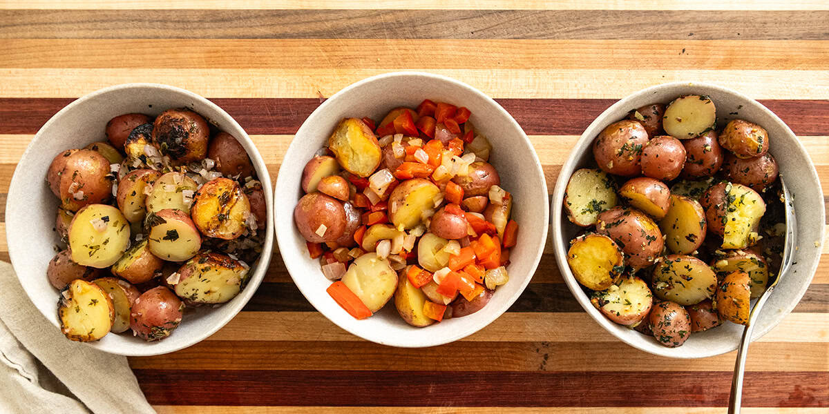 Foil potatoes 3 ways on a cutting board.